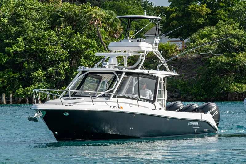 Kirby 107 Yacht Photos Pics 2014 Everglades 350LX boat cruising on a scenic waterway with lush greenery.