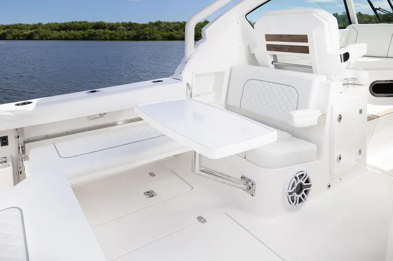  Yacht Photos Pics Manufacturer Provided Image: 2025 Pursuit DC 326 Dual Console boat interior with seating and table, on calm water.