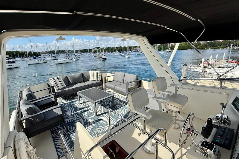 Moonlight Mist Yacht Photos Pics Luxurious 1987 Chris-Craft 500 Constellation yacht interior with elegant seating and scenic marina view.