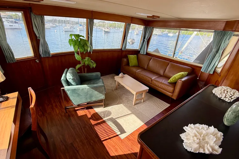 Moonlight Mist Yacht Photos Pics 1987 Chris-Craft 500 Constellation yacht interior with leather sofa, armchair, and scenic marina view.