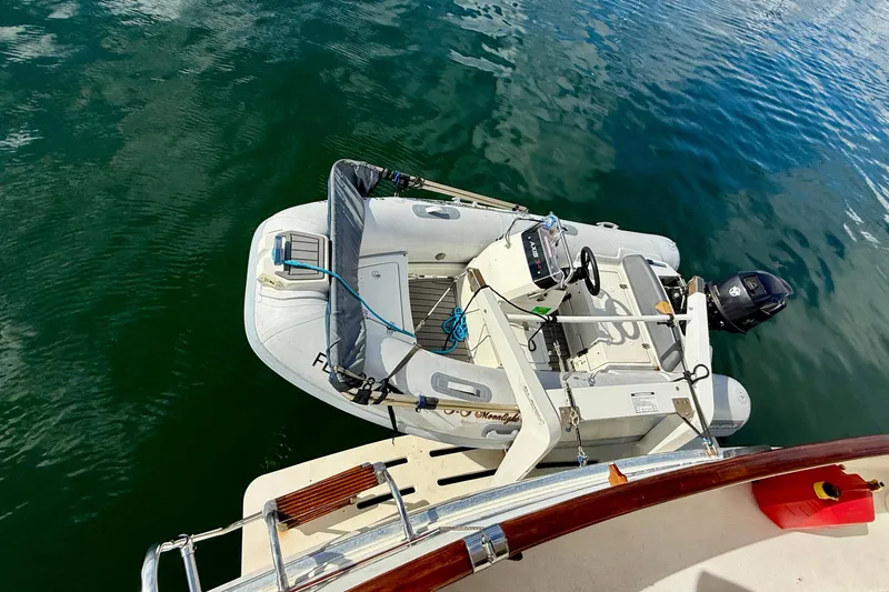 Moonlight Mist Yacht Photos Pics 1987 Chris-Craft 500 Constellation yacht with attached inflatable dinghy on calm water.