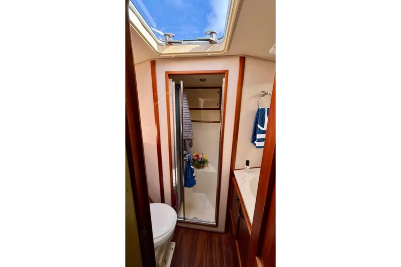 Moonlight Mist Yacht Photos Pics 1987 Chris-Craft 500 Constellation yacht bathroom with skylight, shower, and wooden accents.