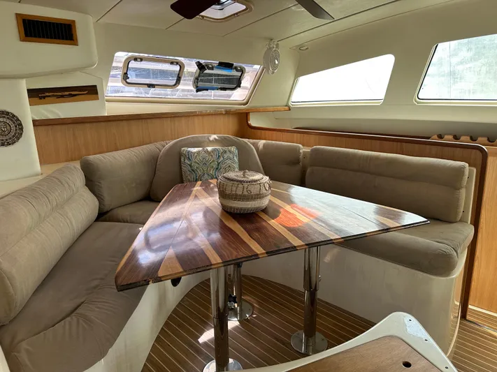 Bat Ha Yam Yacht Photos Pics Interior of 2001 Leopard 47 yacht with cozy seating and wooden table.