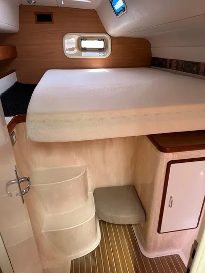 Bat Ha Yam Yacht Photos Pics Interior cabin of a 2001 Leopard 47 yacht with bed and wooden flooring.