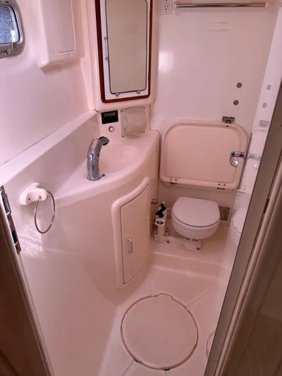 Bat Ha Yam Yacht Photos Pics Bathroom interior of a 2001 Leopard 47 yacht, featuring sink, toilet, and mirror.