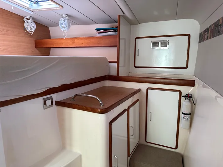 Bat Ha Yam Yacht Photos Pics Interior cabin of a 2001 Leopard 47 yacht with storage and fire extinguisher.