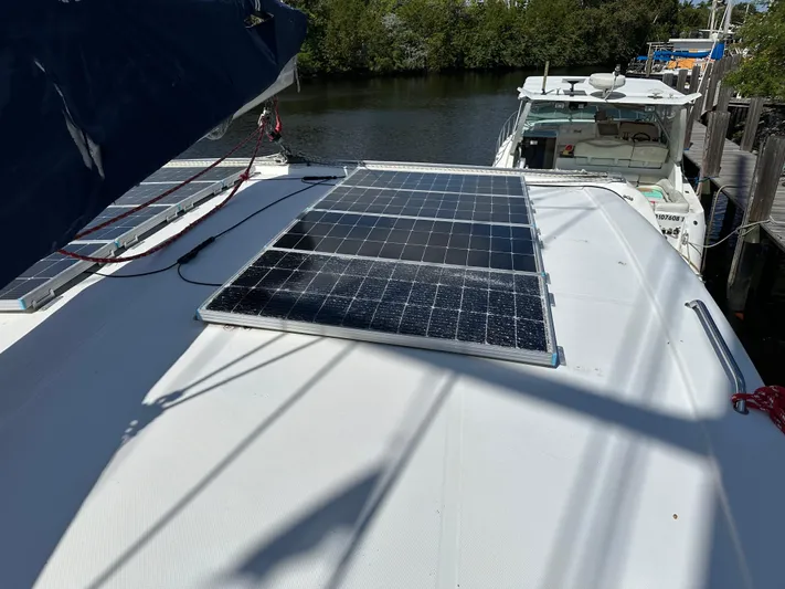 Bat Ha Yam Yacht Photos Pics Solar panels on 2001 Leopard 47 yacht deck, docked near water and trees.