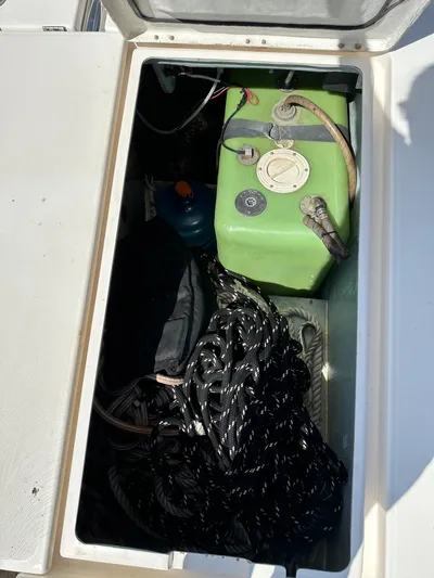 Bat Ha Yam Yacht Photos Pics Storage compartment on a 2001 Leopard 47 boat with green fuel tank and coiled rope.