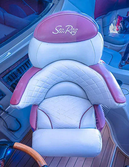 Carolina Girl Yacht Photos Pics Luxurious captain's chair on 2002 Sea Ray 550 Sundancer yacht, featuring white and pink upholstery.