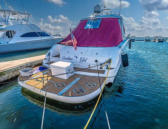 Carolina Girl Yacht Photos Pics 2002 Sea Ray 550 Sundancer docked with red cover and American flag.