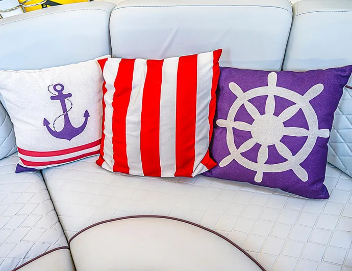 Carolina Girl Yacht Photos Pics Nautical-themed cushions on a Sea Ray 550 Sundancer yacht, featuring anchor and ship wheel designs.
