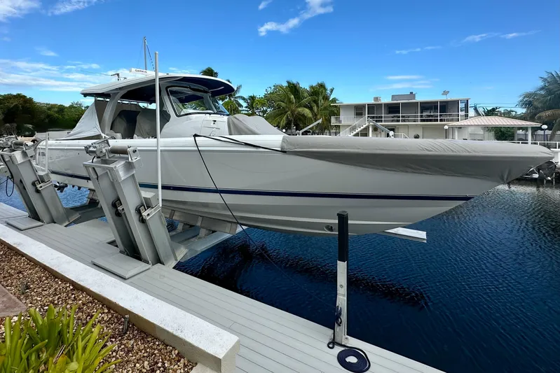  Yacht Photos Pics 2025 Intrepid 43 Nomad SE boat docked on a lift by waterfront property.