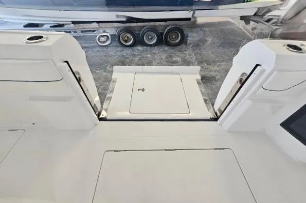  Yacht Photos Pics 2025 Intrepid 43 Nomad SE boat interior with open deck hatch and trailer in background.