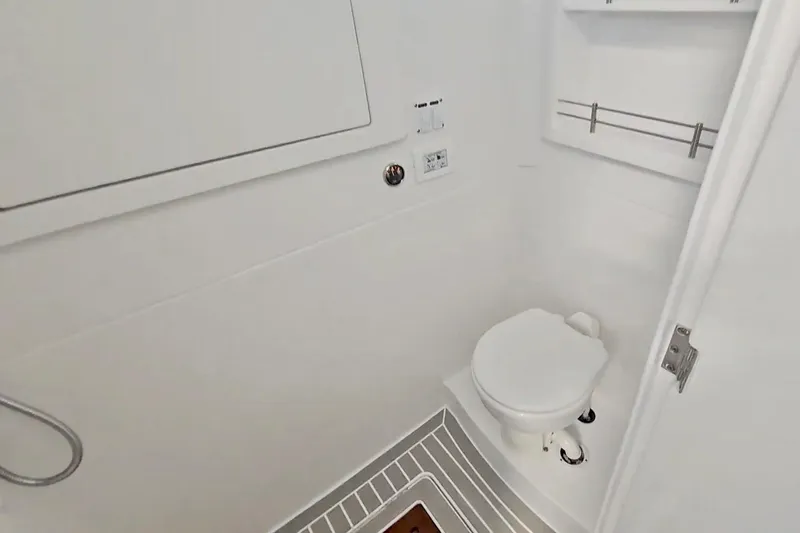  Yacht Photos Pics 2025 Intrepid 43 Nomad SE boat bathroom with white interior and compact toilet.