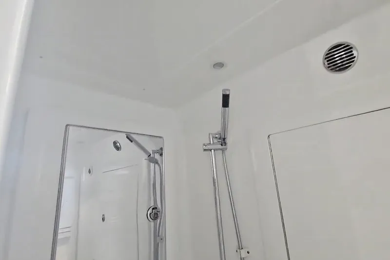  Yacht Photos Pics Shower area inside 2025 Intrepid 43 Nomad SE boat, featuring modern fixtures and ventilation.