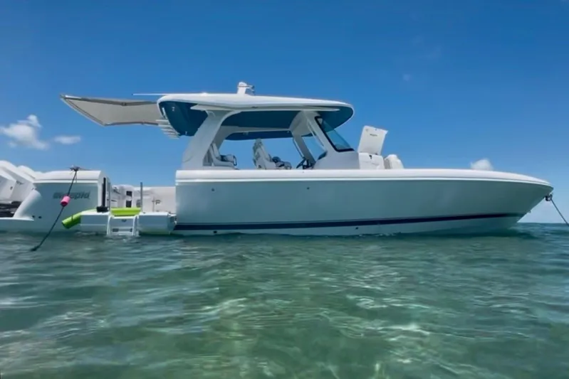  Yacht Photos Pics 2025 Intrepid 43 Nomad SE boat on clear blue water under a sunny sky.