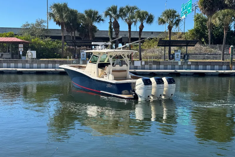  Yacht Photos Pics 2019 Scout 355 LXF boat with triple outboard engines docked near palm trees.