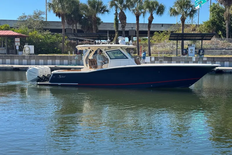  Yacht Photos Pics 2019 Scout 355 LXF boat docked in a marina with palm trees in the background.