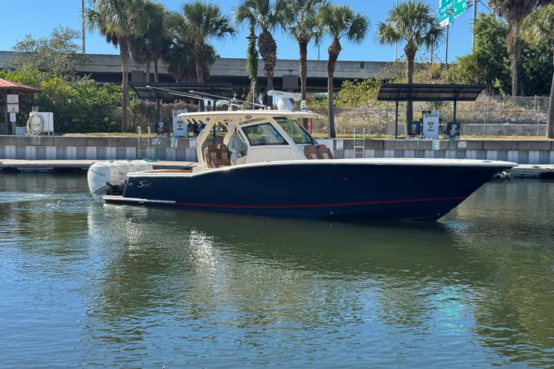  Yacht Photos Pics 2019 Scout 355 LXF boat docked near palm trees and water.