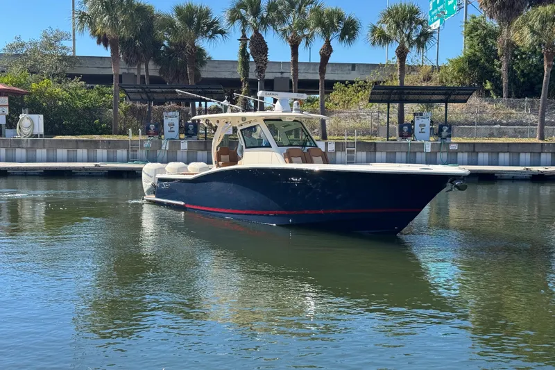  Yacht Photos Pics 2019 Scout 355 LXF boat docked in a marina with palm trees.