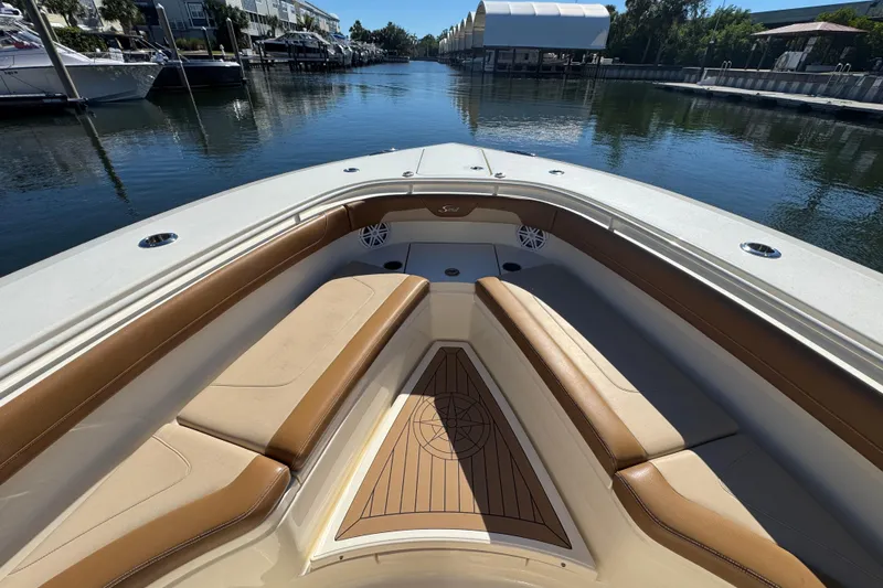  Yacht Photos Pics 2019 Scout 355 LXF boat interior with tan seating, docked in a marina.