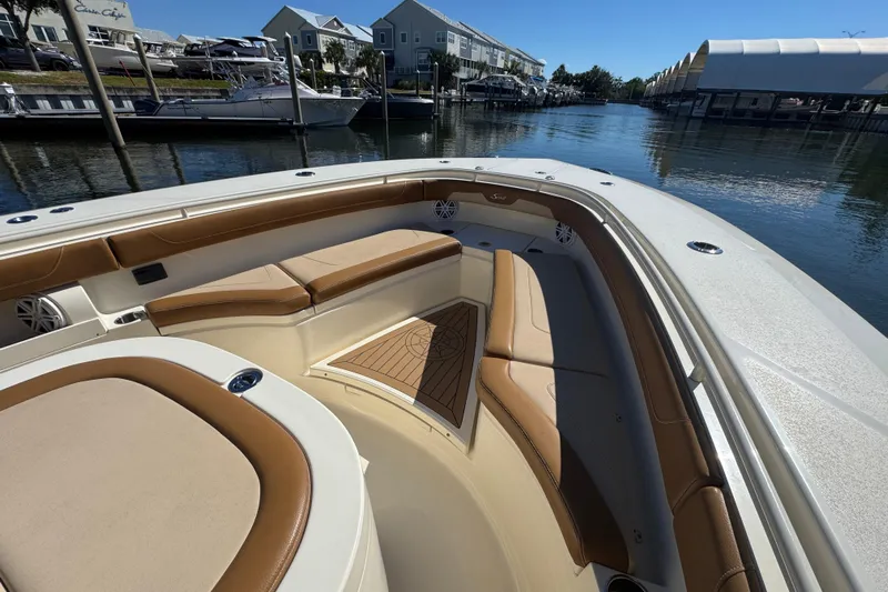  Yacht Photos Pics 2019 Scout 355 LXF boat interior with tan seating, docked in a marina.