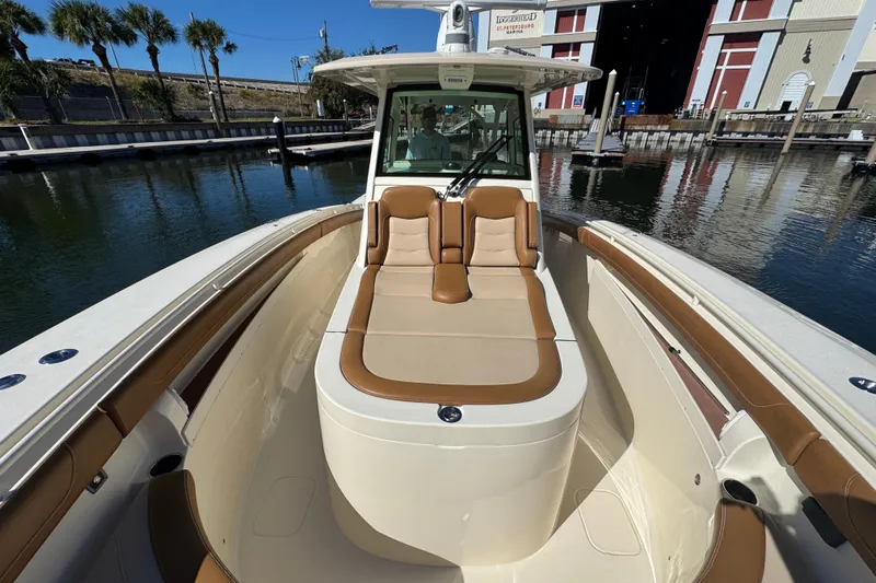  Yacht Photos Pics 2019 Scout 355 LXF boat with tan seating, docked near a marina.