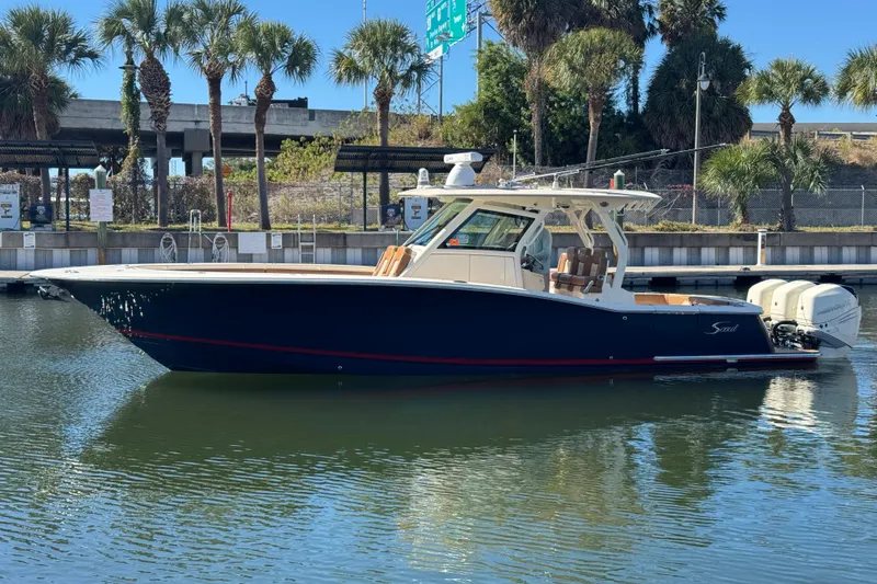  Yacht Photos Pics 2019 Scout 355 LXF boat docked in a marina with palm trees in the background.