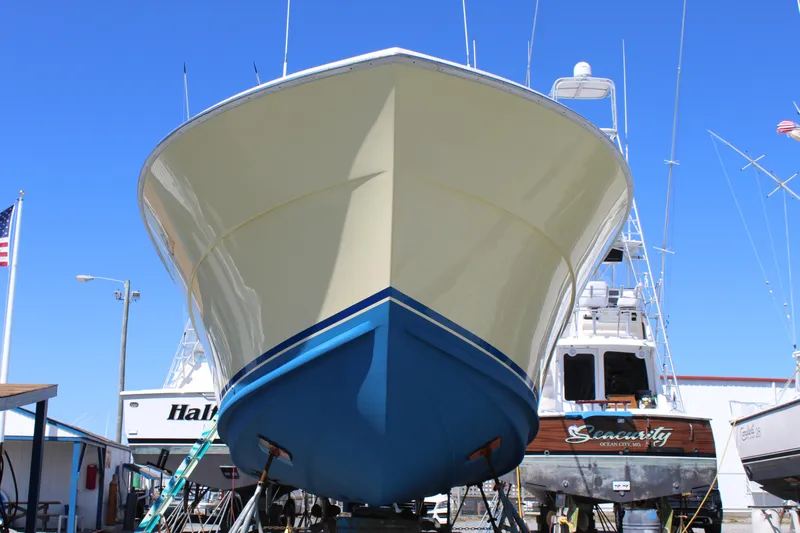 Carolina Girl Yacht Photos Pics 1985 Viking Express boat in dry dock, front view, with clear blue sky.