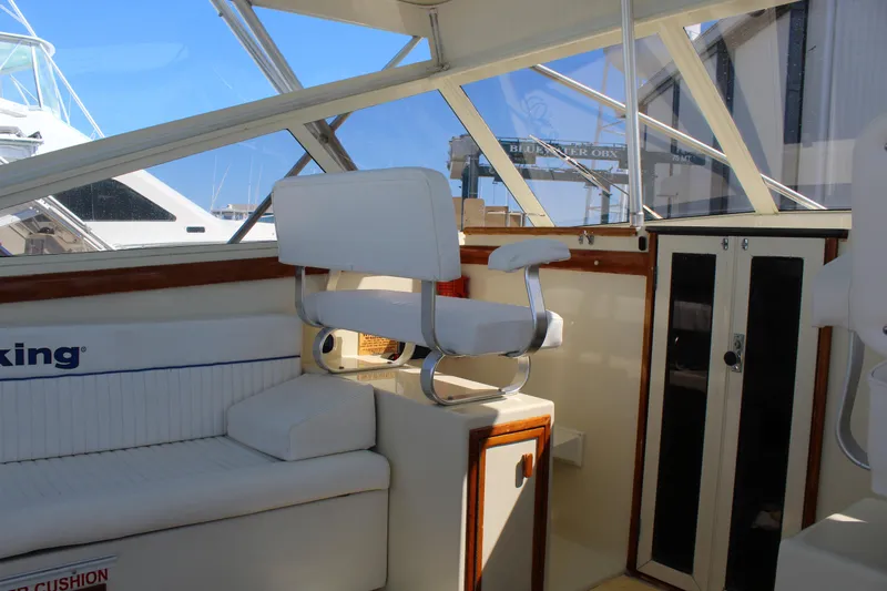 Carolina Girl Yacht Photos Pics Interior of a 1985 Viking Express boat with white seating and wooden accents.