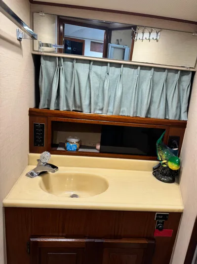 Carolina Girl Yacht Photos Pics 1985 Viking Express bathroom with sink, mirror, and decorative parrot.