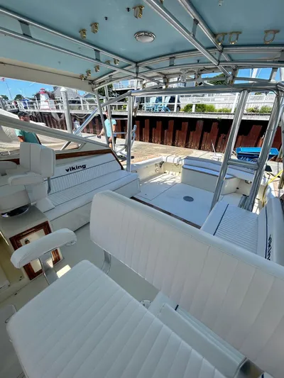 Carolina Girl Yacht Photos Pics 1985 Viking Express boat interior with white seating and metal framework at a dock.