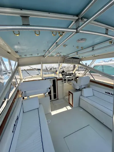 Carolina Girl Yacht Photos Pics 1985 Viking Express boat interior with seating, steering, and blue ceiling.