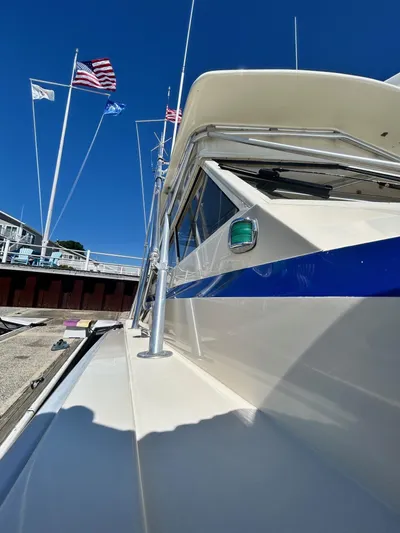 Carolina Girl Yacht Photos Pics 1985 Viking Express boat docked, featuring sleek design and vibrant blue stripe under clear sky.