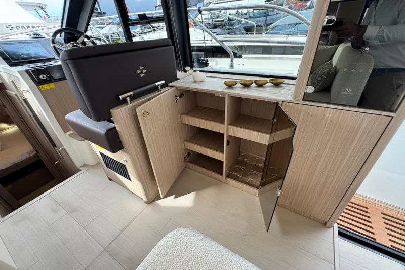  Yacht Photos Pics Interior of 2026 Prestige Yachts F4.3, featuring open wooden cabinets and helm station.