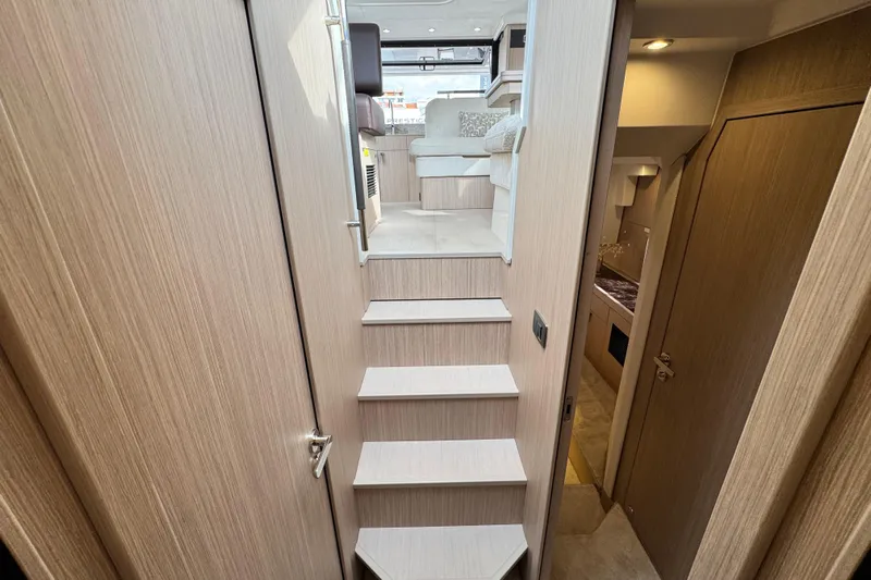  Yacht Photos Pics Interior of 2026 Prestige Yachts F4.3, featuring modern wooden stairs and cozy cabin.