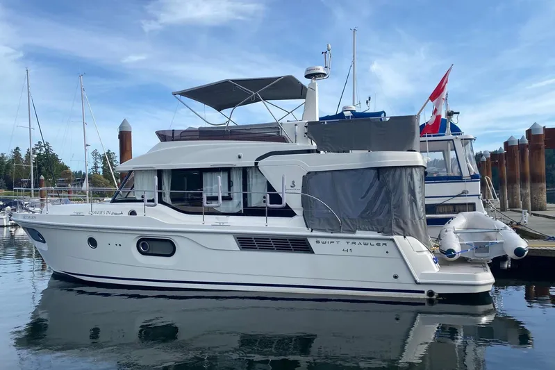 Changes In Latitude Yacht Photos Pics 2022 Beneteau Swift Trawler 41 Fly docked at marina, side view.