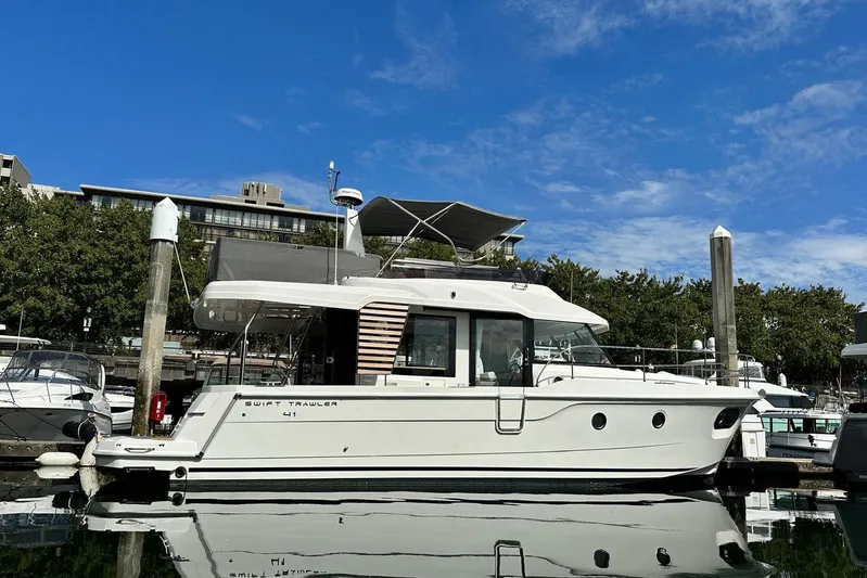 Changes In Latitude Yacht Photos Pics 2022 Beneteau Swift Trawler 41 Fly docked at marina under clear blue sky.