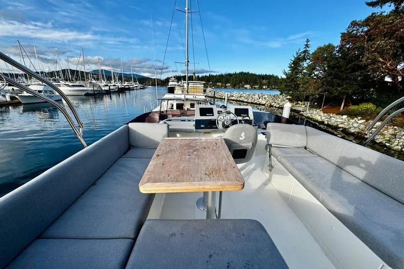 Changes In Latitude Yacht Photos Pics 2022 Beneteau Swift Trawler 41 Fly, spacious deck with seating, docked in scenic marina.