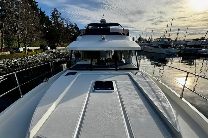 Changes In Latitude Yacht Photos Pics 2022 Beneteau Swift Trawler 41 Fly docked at marina, under a cloudy sky.