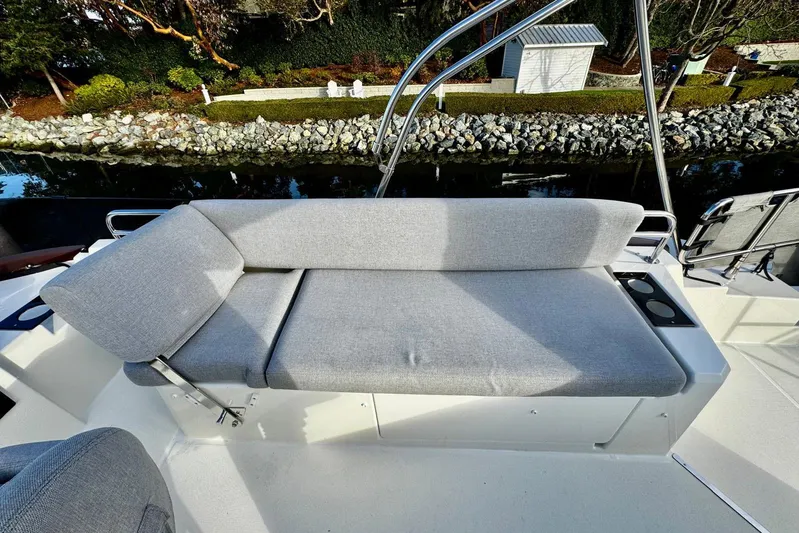 Changes In Latitude Yacht Photos Pics 2022 Beneteau Swift Trawler 41 Fly, gray cushioned seating on deck, near water and greenery.