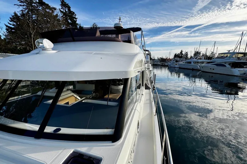 Changes In Latitude Yacht Photos Pics 2022 Beneteau Swift Trawler 41 Fly docked in a serene marina setting.