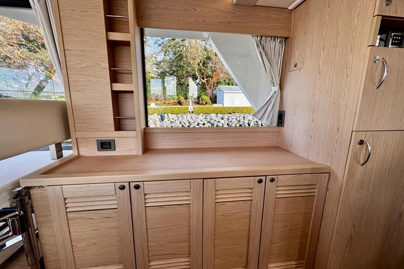 Changes In Latitude Yacht Photos Pics Interior of 2022 Beneteau Swift Trawler 41 Fly with wooden cabinetry and window view.