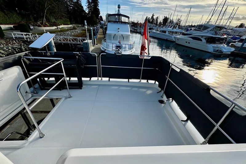 Changes In Latitude Yacht Photos Pics 2022 Beneteau Swift Trawler 41 Fly at marina, featuring spacious deck and scenic waterfront view.