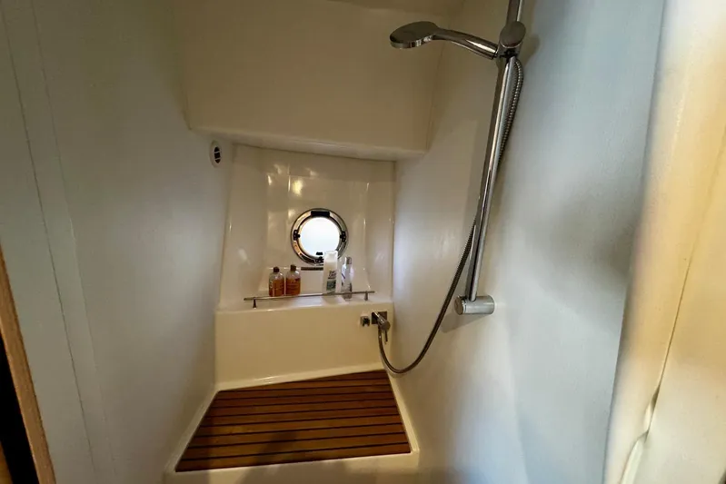 Changes In Latitude Yacht Photos Pics Shower area in 2022 Beneteau Swift Trawler 41 Fly with porthole and wooden floor.