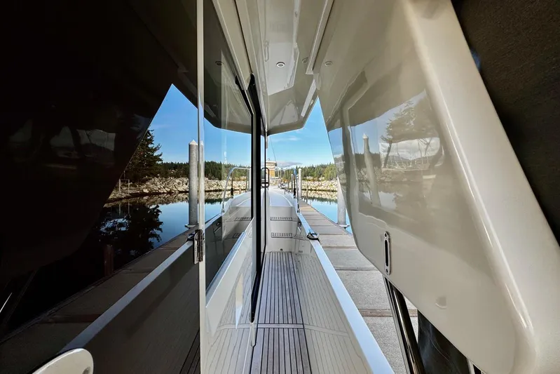 Changes In Latitude Yacht Photos Pics 2022 Beneteau Swift Trawler 41 Fly, side deck view with scenic marina backdrop.