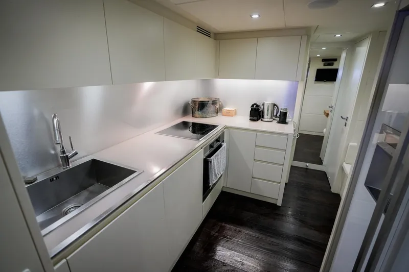 My Veloce Yacht Photos Pics Modern kitchen interior on a 2013 Pershing 82 yacht, featuring sleek cabinetry and appliances.