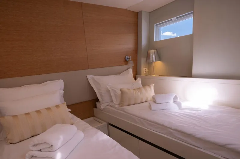  Yacht Photos Pics Luxurious twin cabin interior on 2022 Prestige 590 yacht, featuring elegant bedding and soft lighting.