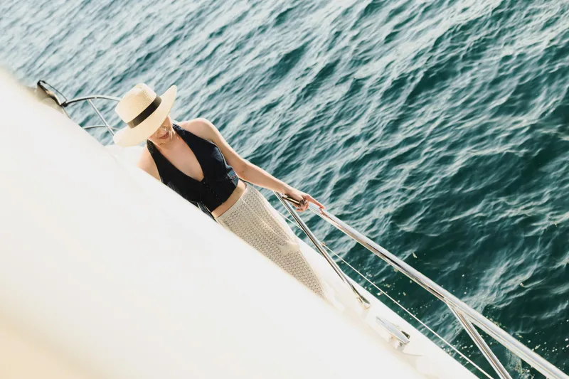  Yacht Photos Pics Woman in hat on Prestige 590 yacht, 2022, enjoying ocean view.