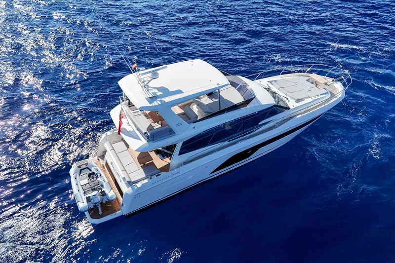  Yacht Photos Pics Aerial view of 2022 Prestige 590 yacht cruising on blue ocean waters.
